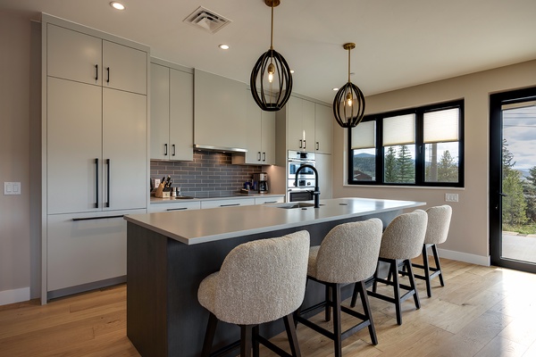 Your modern kitchen awaits, where stylish pendant lighting and sleek countertops set the stage for memorable meals. Gather around the island with mountain views as your backdrop, and let this inviting space become the heart of your stay.