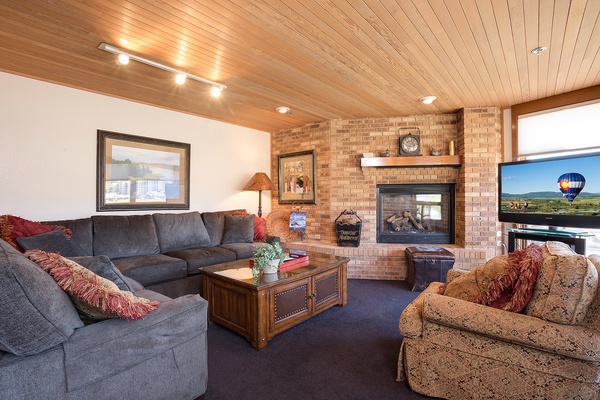 Sink into plush sofas and warm up by the brick fireplace in your inviting living room, where mountain views and ample space create your perfect gathering spot.