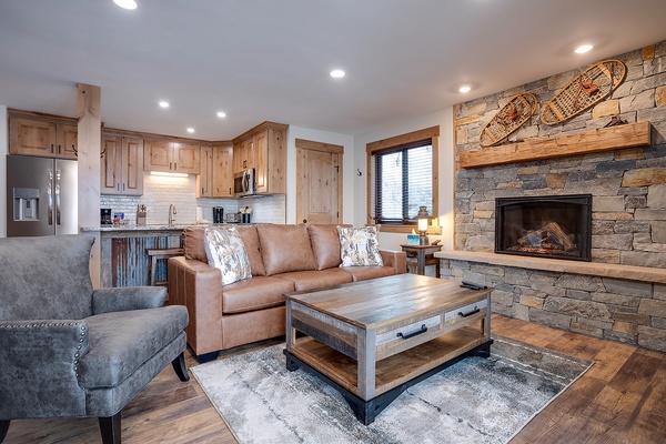 Imagine your evenings here: sink into plush seating by the stone fireplace, with warm wood tones and mountain-inspired decor creating your perfect retreat after a day of adventure.