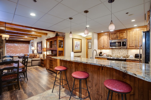 Gather around the spacious kitchen island with granite countertops and modern appliances, or relax in the open living and dining area—perfect for memorable meals and cozy evenings together.