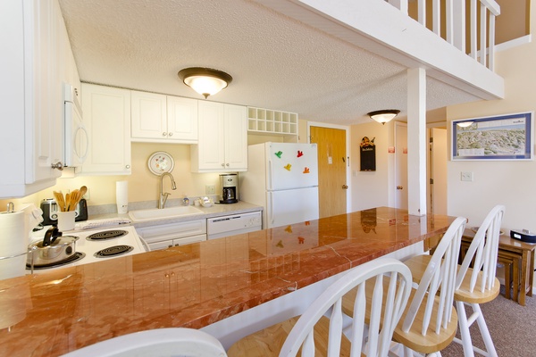 Cook your favorite meals in this fully equipped kitchen with modern appliances, gleaming countertops, and a breakfast bar perfect for your morning coffee.