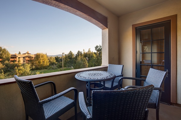 Your private balcony offers a peaceful retreat with comfortable seating, perfect for enjoying morning coffee or evening relaxation while taking in views of the lush surroundings.