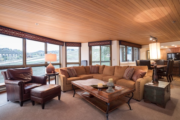 Unwind in your spacious living area with plush seating, warm wood tones, and expansive windows framing scenic mountain views—your perfect retreat after a day of adventure.