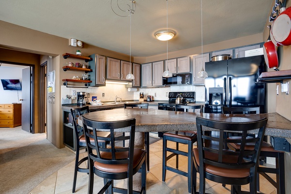 Your spacious kitchen features a grand island with seating for six, stainless steel appliances, and abundant counter space—perfect for preparing meals and gathering with friends and family.
