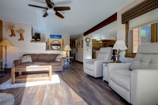 Picture yourself unwinding in this spacious, sun-filled living room with plush recliners and cozy western charm. The open layout flows into the kitchen, making your stay comfortable and inviting.