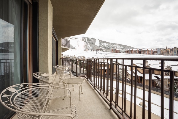 The balcony overlooks snow-covered slopes and mountain views—a perfect spot for your morning coffee or après-ski relaxation with the alpine scenery as your backdrop.