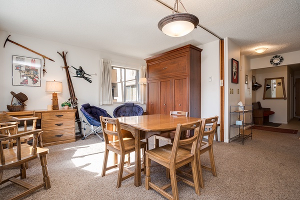 Gather around the sturdy wooden dining table and enjoy meals together in this bright, ski-themed retreat. Natural light fills the space, highlighting rustic mountain touches and vintage ski decor throughout.