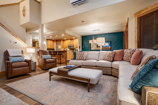 Step into your inviting open-concept living space with vaulted ceilings, plush seating, and warm wood accents creating a cozy mountain retreat atmosphere you'll love coming home to.