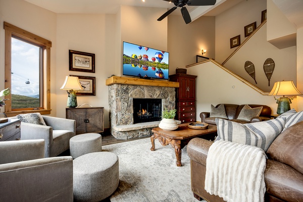 Sink into plush seating beside a crackling stone fireplace, where vaulted ceilings and mountain views through picture windows create your perfect retreat after a day of adventure.