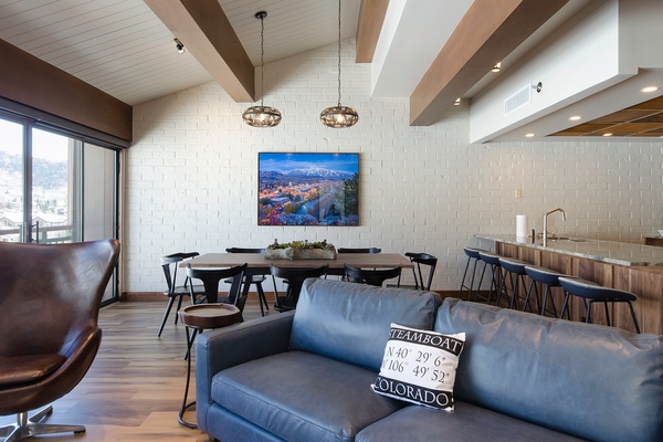 Gather in your open-concept living space featuring exposed beams, modern lighting, and Steamboat coordinates—designed for making memories with family and friends.