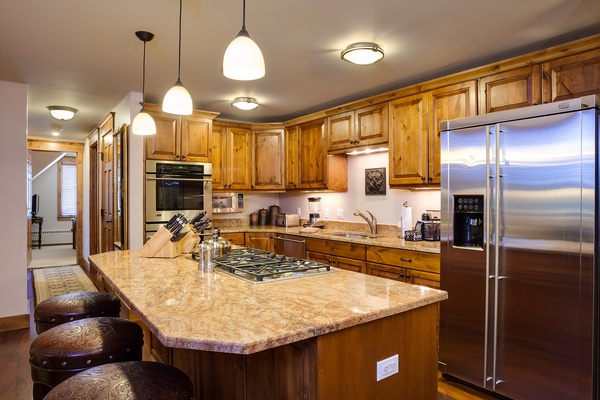 Picture yourself preparing meals in this spacious kitchen, with gleaming granite countertops, rich wood cabinetry, and modern stainless appliances at your fingertips for effortless home-cooked dining.