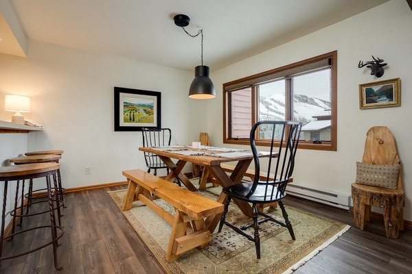 Picture yourself enjoying meals at this rustic dining table, framed by breathtaking mountain views through the window—a perfect blend of cozy charm and natural beauty.