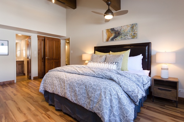 Sink into the plush comfort of this inviting bedroom, styled with crisp linens and warm lighting. The ceiling fan and private bathroom add to your restful retreat.