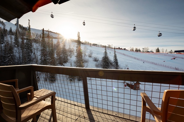 A ski resort at sunrise with snow-covered slopes, pine trees, and ski lifts visible from the property. The area offers direct access to winter sports and mountain recreation.