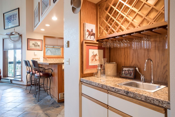 Gather your group at the bar featuring custom wine storage and granite counters, or step through to the breakfast nook framed by western art and natural light streaming in.