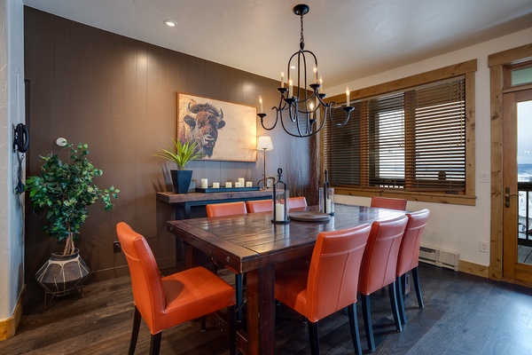 Gather around this handsome dining table with vibrant orange chairs, perfect for enjoying meals together. Warm lighting and rustic mountain-inspired décor set a welcoming tone for your stay.