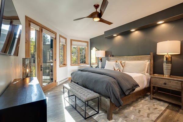 Step into your serene bedroom retreat, where a plush king bed, stylish decor, and natural light through the balcony doors invite you to unwind in comfort.