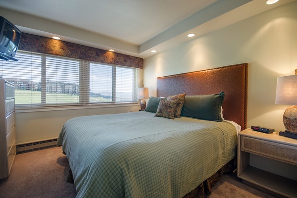 Sink into your plush bed with its designer headboard and crisp linens. Large windows frame scenic views, while soft lighting and tasteful decor create a restful retreat.