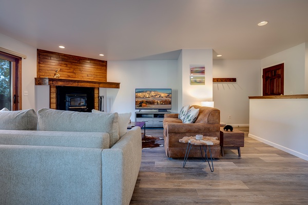 Settle into your open-concept living space, where a warm wood-burning fireplace, plush seating, and stunning mountain views create the perfect retreat after exploring.