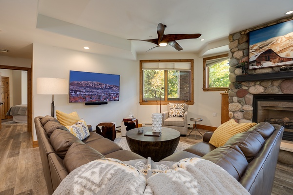 Sink into plush leather sofas in your bright, inviting living room. Warm up by the stone fireplace, relax with your favorite show, and enjoy mountain views through sunlit windows.