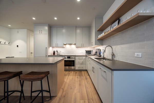 Step into your sleek, fully-equipped kitchen with modern appliances and stylish finishes. Open shelving and a breakfast bar invite you to whip up meals or sip morning coffee in comfort.
