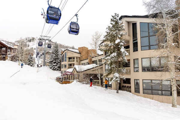 A premier ski resort village with gondola access steps from the property, surrounded by snow-covered slopes and mountain vistas.
