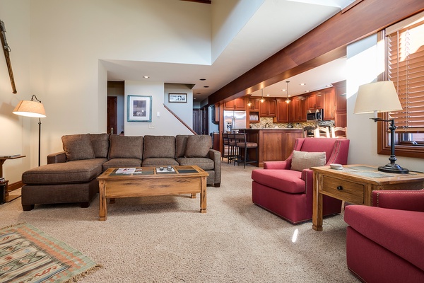 Sink into the plush sectional and enjoy your open-concept retreat, where the inviting living space flows into a fully equipped kitchen—perfect for relaxing or cooking together.