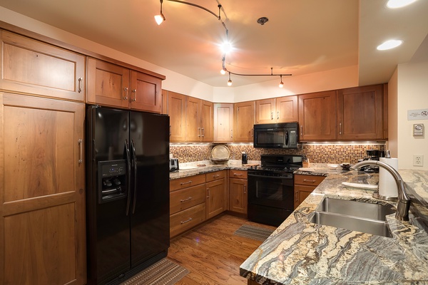 Your spacious kitchen invites culinary adventures with warm wood cabinetry, gleaming granite countertops, and modern appliances ready for your favorite recipes.