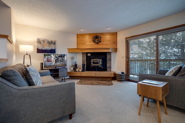 Sink into plush sofas by your private fireplace and enjoy streaming your favorites on the TV. Natural light pours through expansive windows overlooking the trees, creating your perfect retreat.