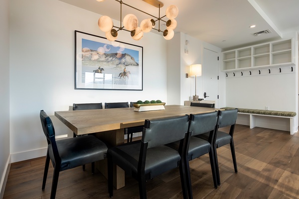 Gather around this elegant dining table under modern lighting—perfect for sharing meals and making memories with your group.