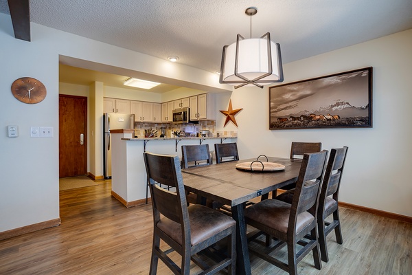Gather around this spacious dining table for meals and memories, with a fully equipped kitchen just steps away for your culinary adventures.