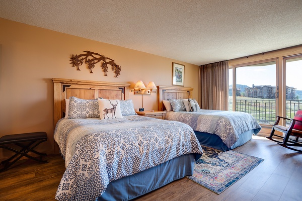 Unwind in this inviting bedroom with two plush queen beds, mountain-themed décor, and your own private balcony overlooking sweeping mountain and valley views.