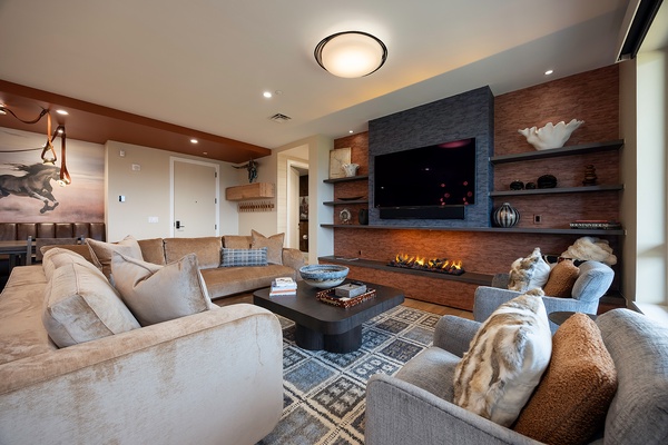 Sink into plush seating and feel the warmth of the glowing fireplace as you unwind in this inviting living room, where modern comfort meets mountain elegance.