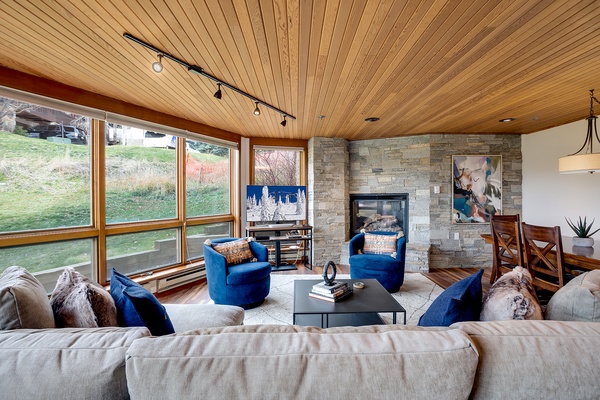 Sink into plush seating, warm up by the fireplace, and gaze through expansive windows framing peaceful natural views—your ideal retreat awaits.