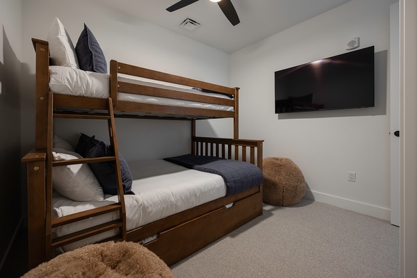 Your kids will love this cozy bunk room, complete with soft linens, plush seating, and a wall-mounted TV for movie nights after a day of adventure.