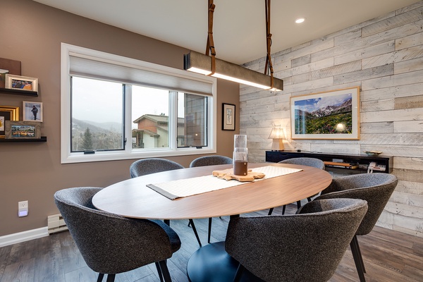 Gather around this stylish oval table for meals or conversation, surrounded by modern comfort and natural mountain light streaming through your window.