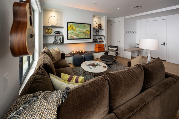 Settle into this inviting living space where modern design meets personal comfort. Sink into plush seating near the warm glow of the fireplace, strum the guitar, or simply unwind surrounded by curated art and thoughtful details.