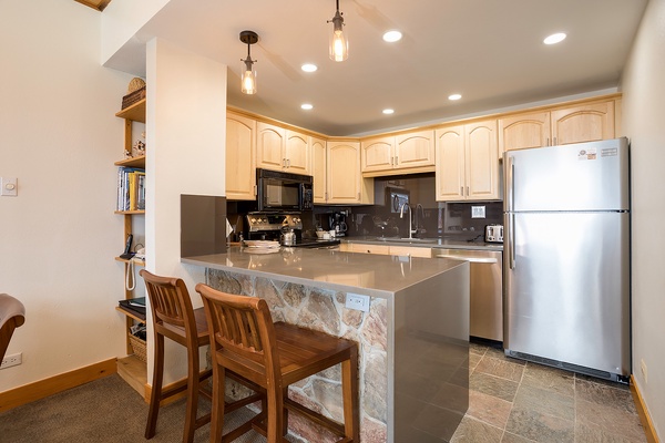Your fully equipped kitchen awaits, complete with modern appliances, ample counter space, and a breakfast bar for casual dining and morning coffee rituals.