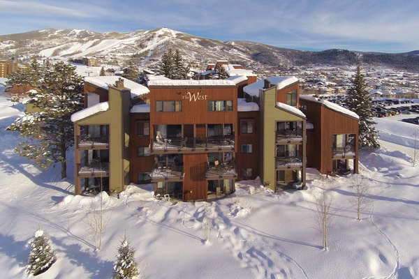 A winter wonderland awaits at The West Condominiums, nestled in a pristine mountain valley with snow-covered peaks rising all around. This property features cozy balconies and sits near ski slopes.