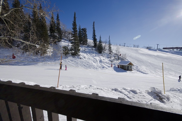 The property sits at the base of ski slopes, providing direct access to winter sports and scenic mountain terrain surrounded by evergreen trees.