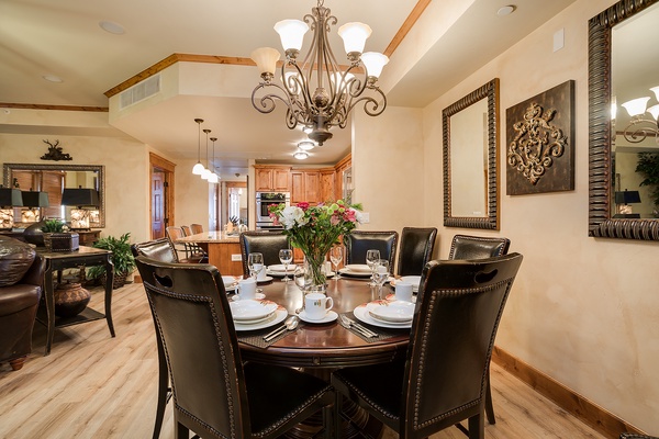 Gather around this elegant dining table for memorable meals together, where a stunning chandelier and thoughtful décor create the perfect setting for your group's shared moments.