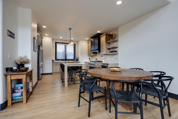Your open-concept kitchen and dining area invites you to gather around the rustic wood table, cook meals in the modern kitchen, and feel right at home in this warm, thoughtfully designed space.
