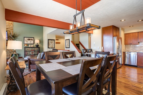 Gather around this spacious dining table with seating for eight, where warm wood tones and modern lighting create the perfect setting for your memorable vacation meals together.