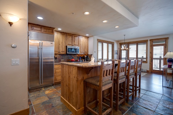 Gather around the breakfast bar in your fully-equipped kitchen, where rustic wood and granite invite you to start each morning with mountain views through large windows.