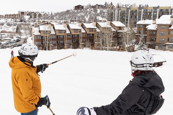 A winter ski resort area featuring slope-side lodging and ski-in access, surrounded by snow-covered terrain and mountain village architecture visible in the background.