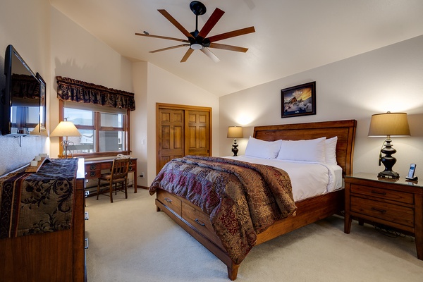 Your spacious bedroom welcomes you with rich wood furnishings, plush linens, and vaulted ceilings. A ceiling fan keeps you comfortable while bedside lamps and a desk offer convenience.