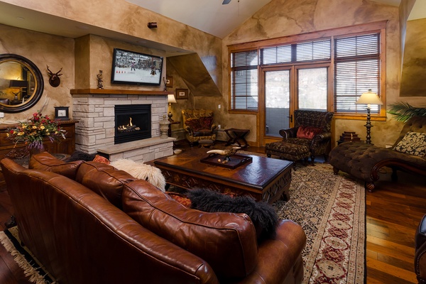 Sink into rich leather seating by your private stone fireplace, where warm wood tones and mountain elegance create the perfect retreat after your adventures.