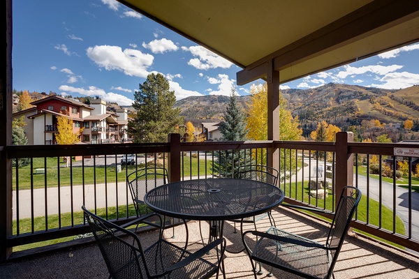 Covered balcony overlooks autumn-clad mountains and neighborhood streets, offering a peaceful spot to enjoy seasonal views and fresh mountain air.