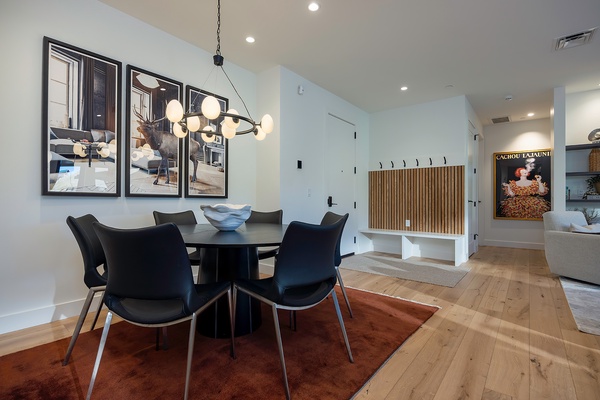 Gather around this sleek dining table for shared meals and conversation, warmed by modern lighting and tasteful art that makes your vacation home feel stylish and welcoming.