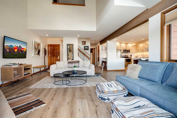 Unwind in your spacious living room with soaring ceilings, plush seating, and an open-concept layout that flows seamlessly into the modern kitchen—perfect for relaxing after a day of adventure.